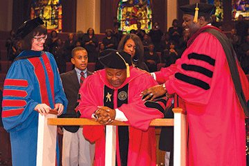 Smith being hooded while his wife, Andrea and son Kamari looks on His ...